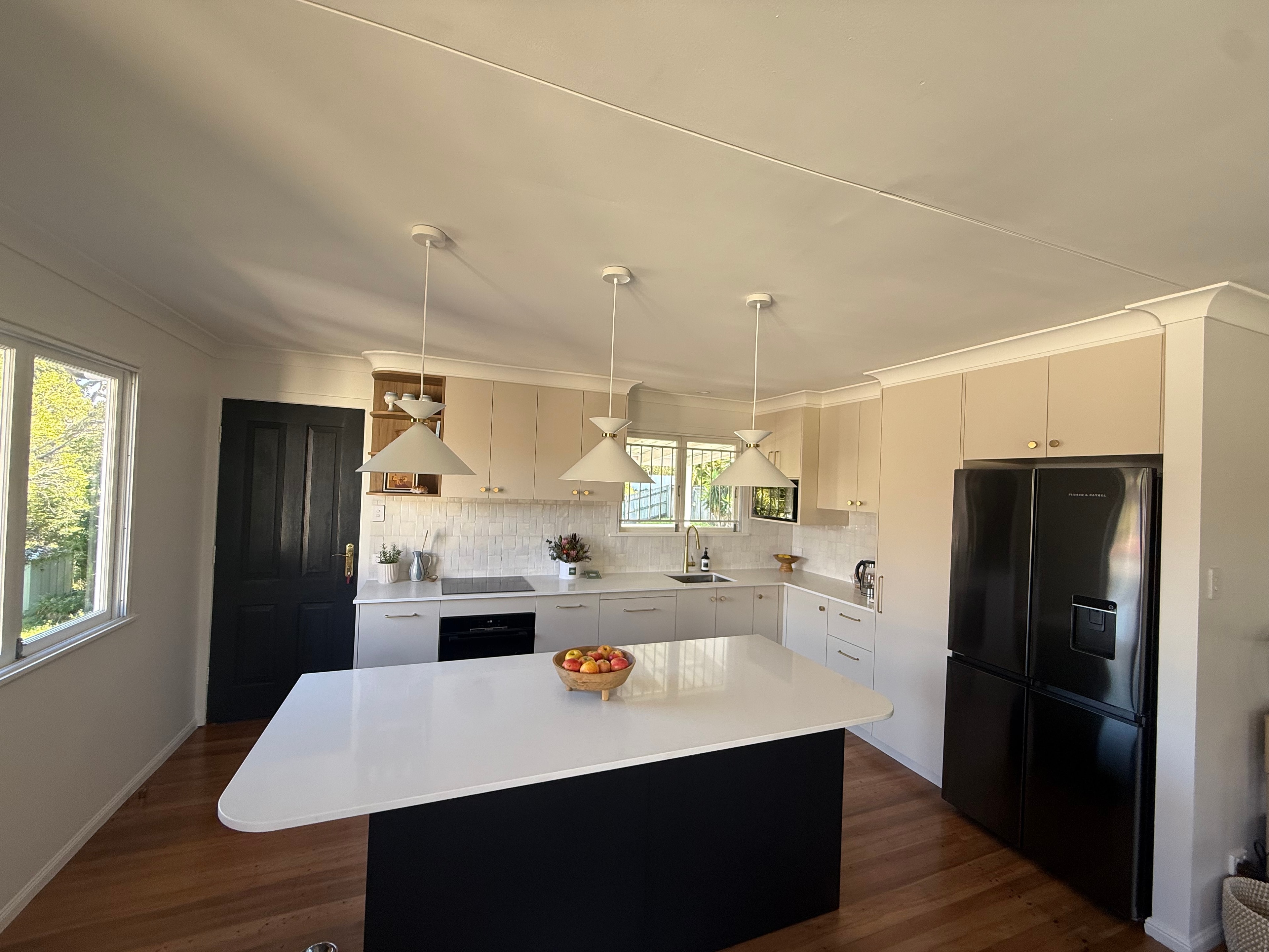 Kitchen with Cream Cabinetry and Black Island